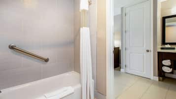 Une salle de bain avec une baignoire, un rideau de douche et un porte-serviettes.