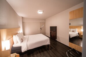 A hotel room with a bed, bedside table, lamp, and a mirror. - ibis Fortaleza Praia de Iracema (Fortaleza)