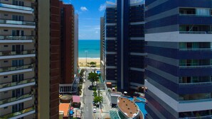 Un hotel moderno de gran altura con varias plantas, un área de piscina y vista a la playa.