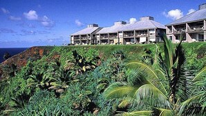 A resort with multiple buildings overlooking a lush, green landscape and the ocean. - Castle at Princeville (Princeville)