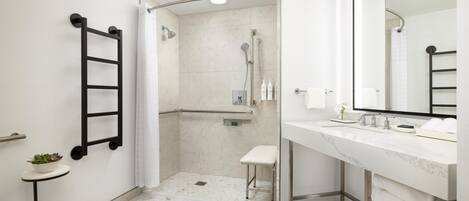 Un baño moderno con ducha, inodoro y lavamanos, con una paleta de colores blanco y gris.