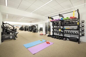 A gym with exercise equipment, mats, and weightlifting accessories. - Hilton Boston Back Bay (Boston)