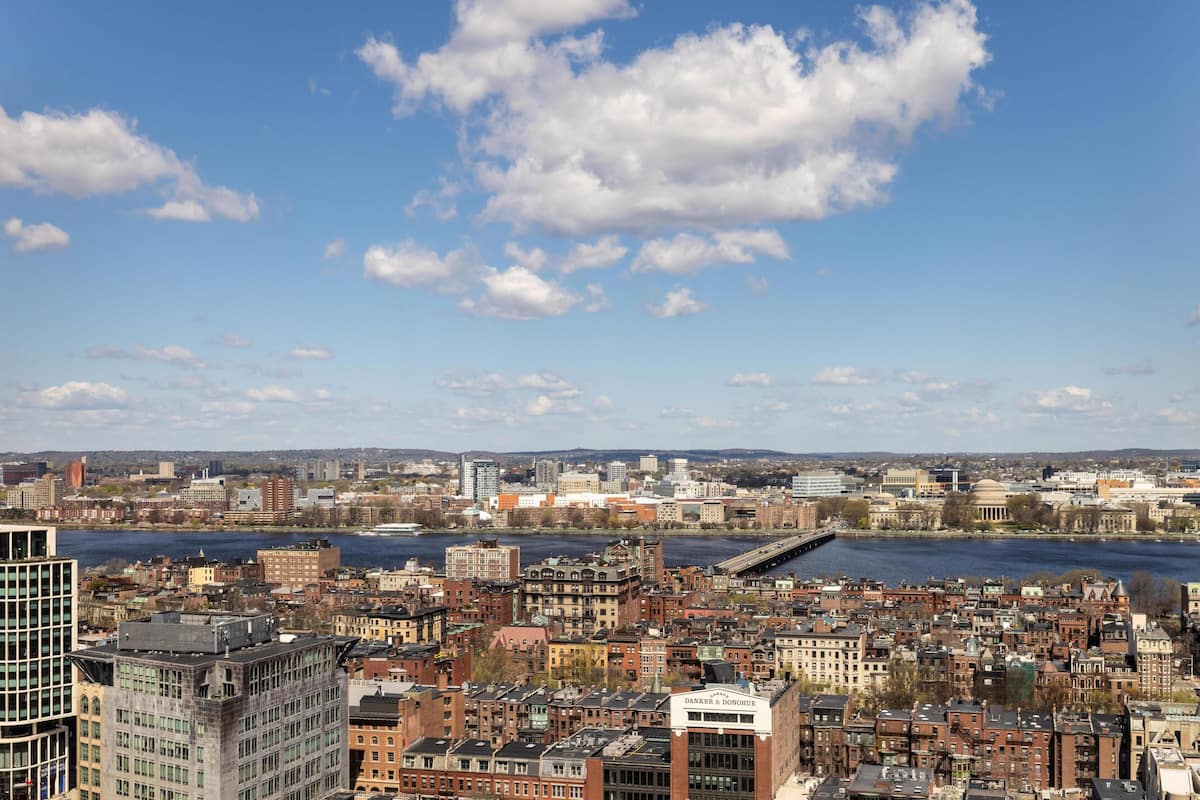 A cityscape with a river, historic buildings, and a modern skyscraper.