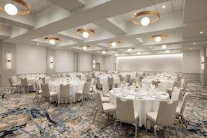 A large conference room with round tables, chairs, and a projector screen. - Hilton Boston Back Bay (Boston)