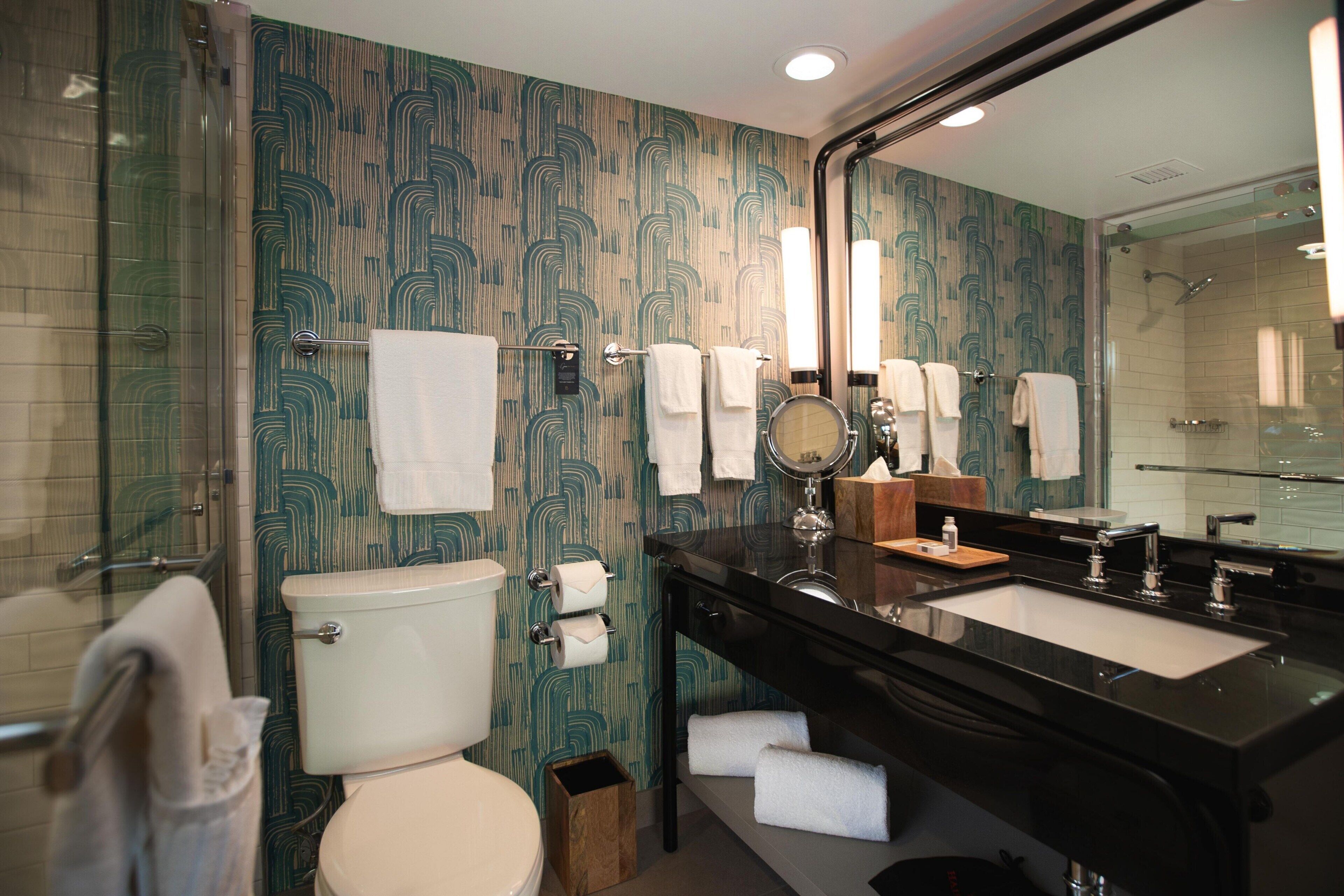 A bathroom with a toilet, sink, and shower.