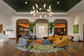 A spacious lobby with a modern chandelier, a seating area with a sofa and armchairs, and a reception desk. - Hotel Mockingbird, Dallas, A Tribute Portfolio Hotel (Dallas)