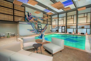 室内游泳池，池  畔遮阳伞，日光浴躺椅