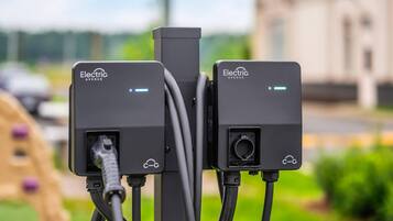 Two electric vehicle charging stations labeled "Electric Avenue" with cables connected to them.