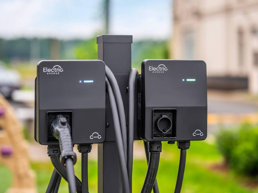 Two electric vehicle charging stations labeled "Electric Avenue" with cables connected to them.