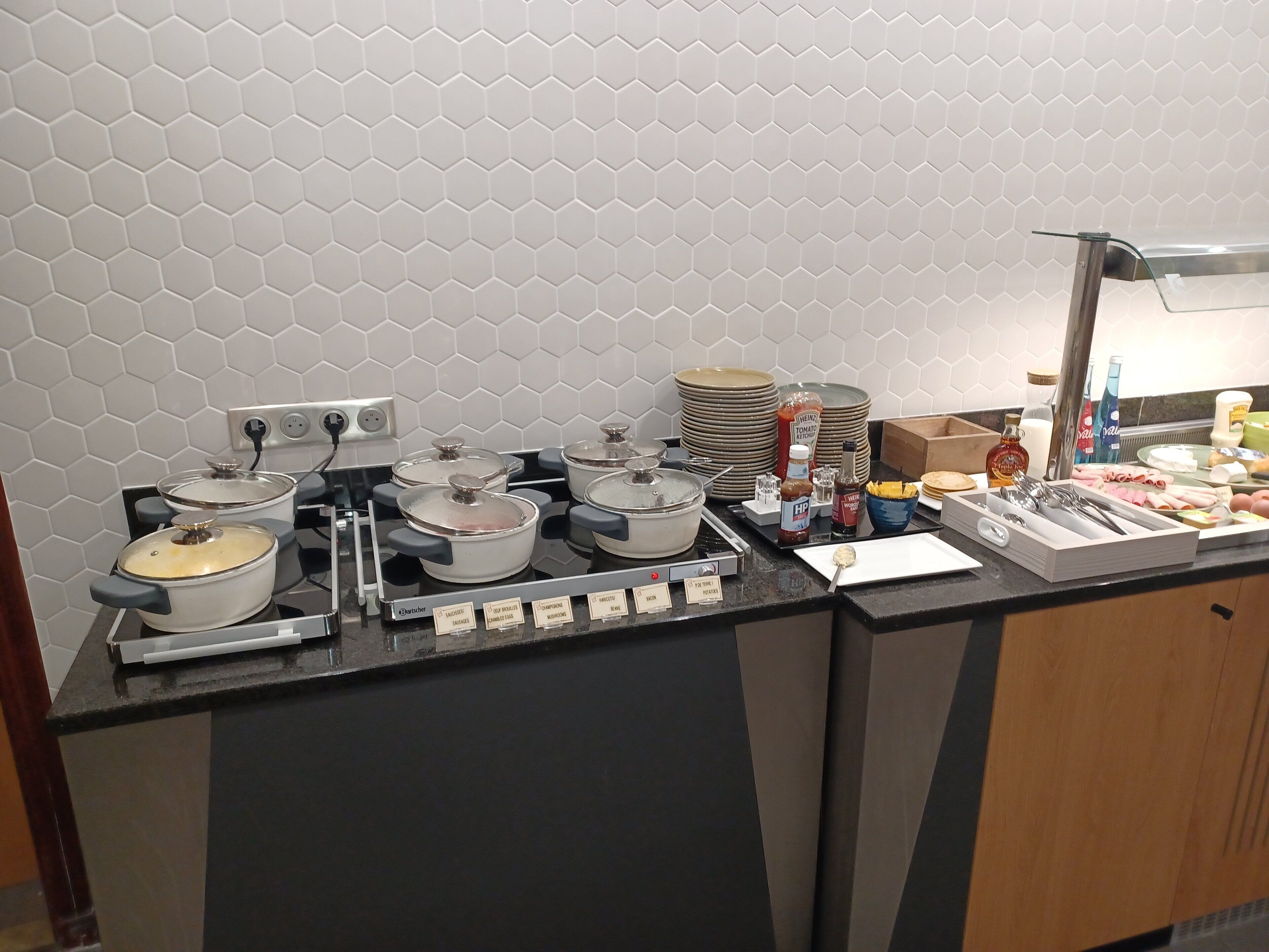 A buffet setup with various food items and condiments.