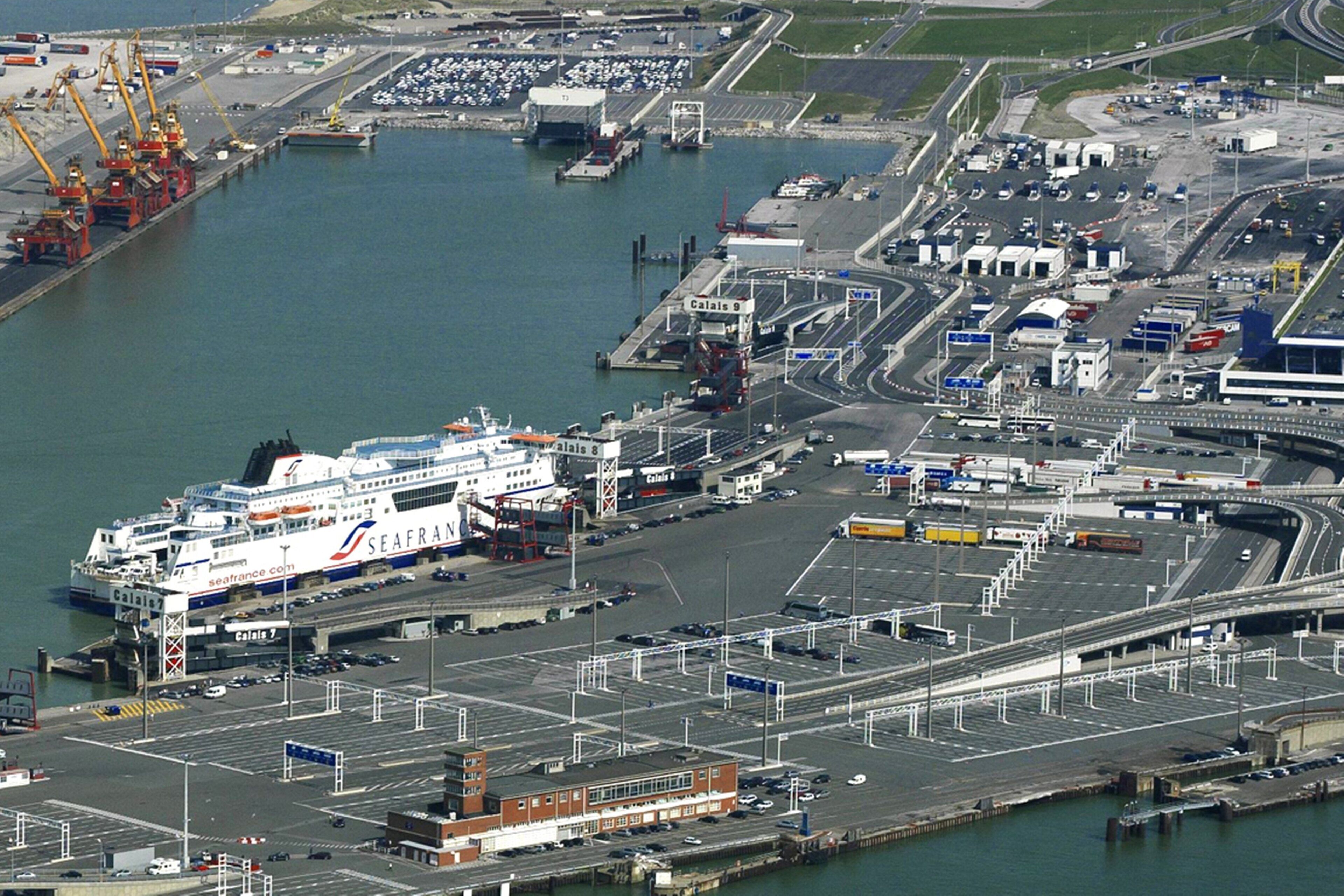 Un ferri gran amarrat en un port amb diverses vies d'accés i zones d'aparcament.