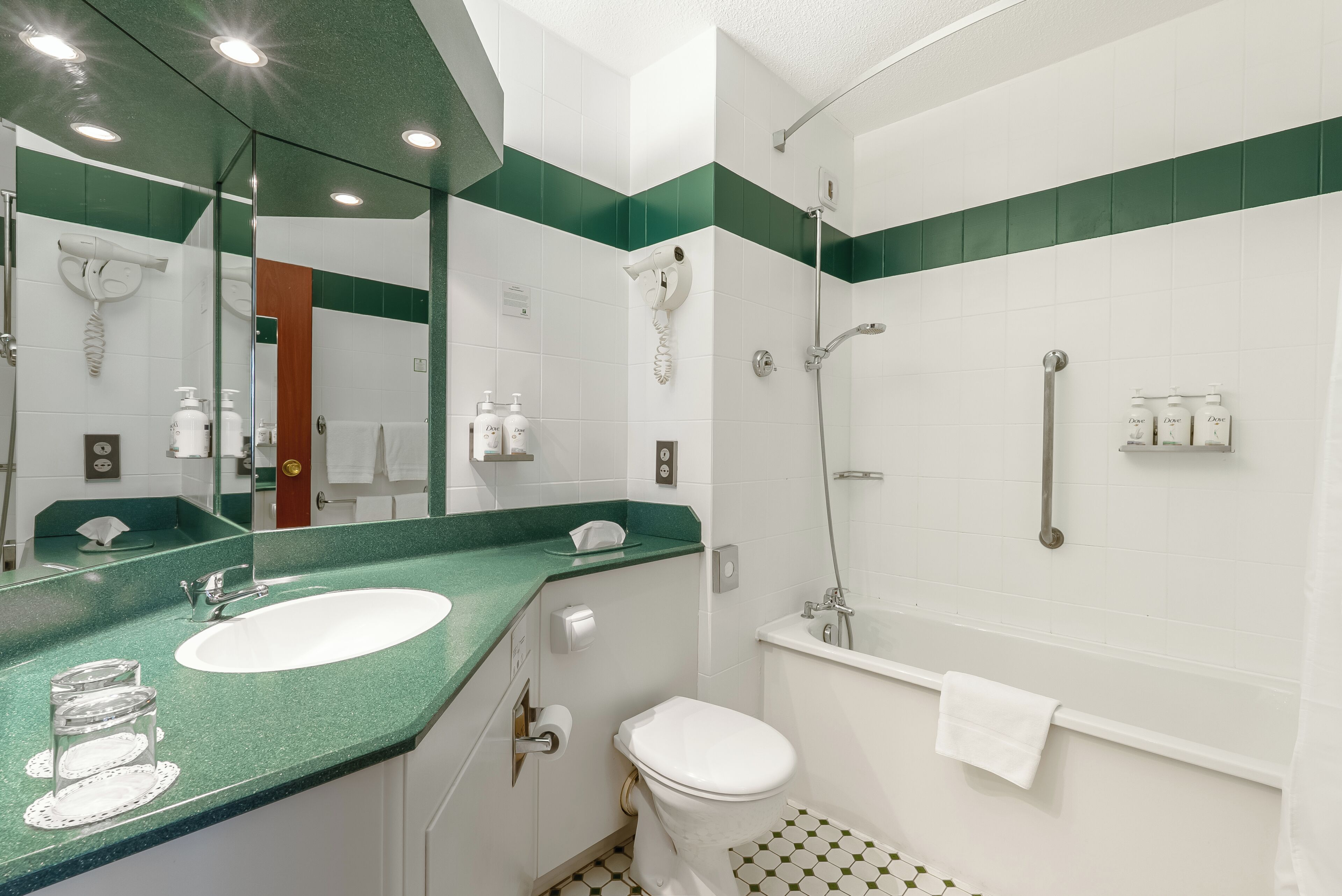 Un baño con lavamanos, inodoro y ducha.