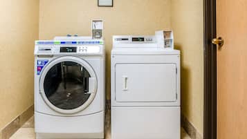 A laundry room with a front-loading washing machine and a stacked dryer.