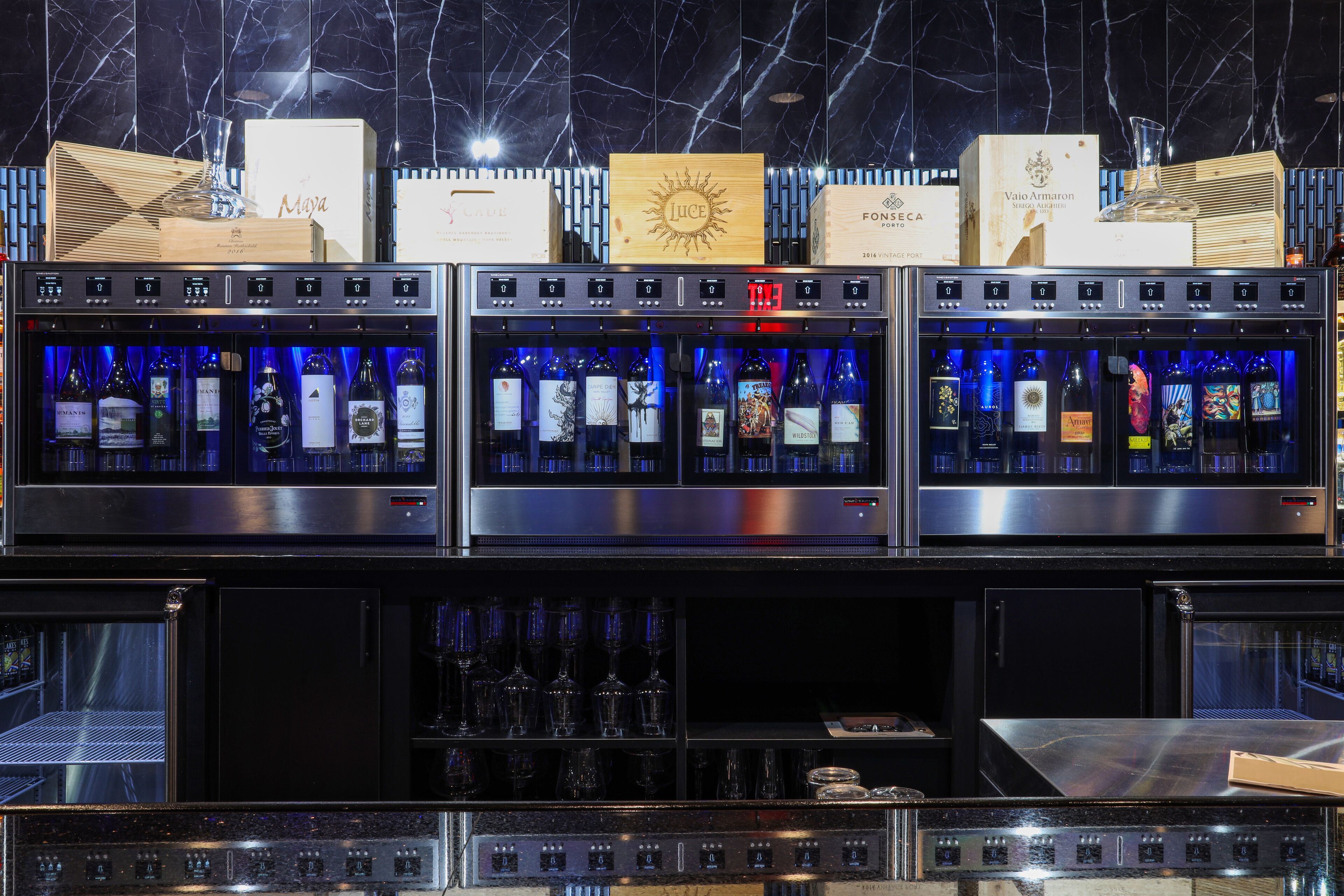 A bar area with multiple wine dispensers and a selection of bottles.