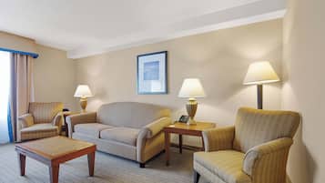 A hotel room with a sofa, two armchairs, a coffee table, and two lamps.