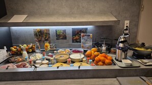 A buffet with various food items and a coffee machine.