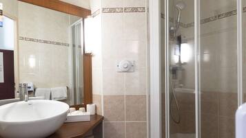 Une salle de bain avec un grand lavabo, des toilettes et une douche à parois de verre.