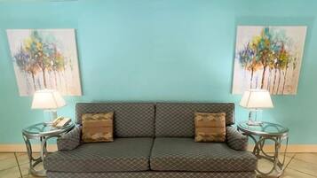 Relax in this stylish living room with a sofa, side tables, and lamps, surrounded by abstract artwork.