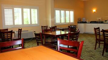 Enjoy meals and gatherings around the large table in this spacious dining area with adjacent kitchen.