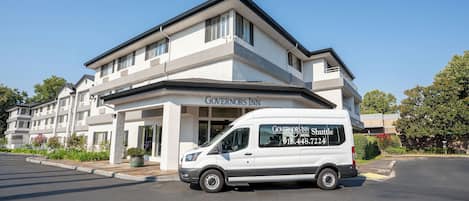 Una camioneta blanca estacionada frente a un edificio con el letrero 'Governors Inn'.