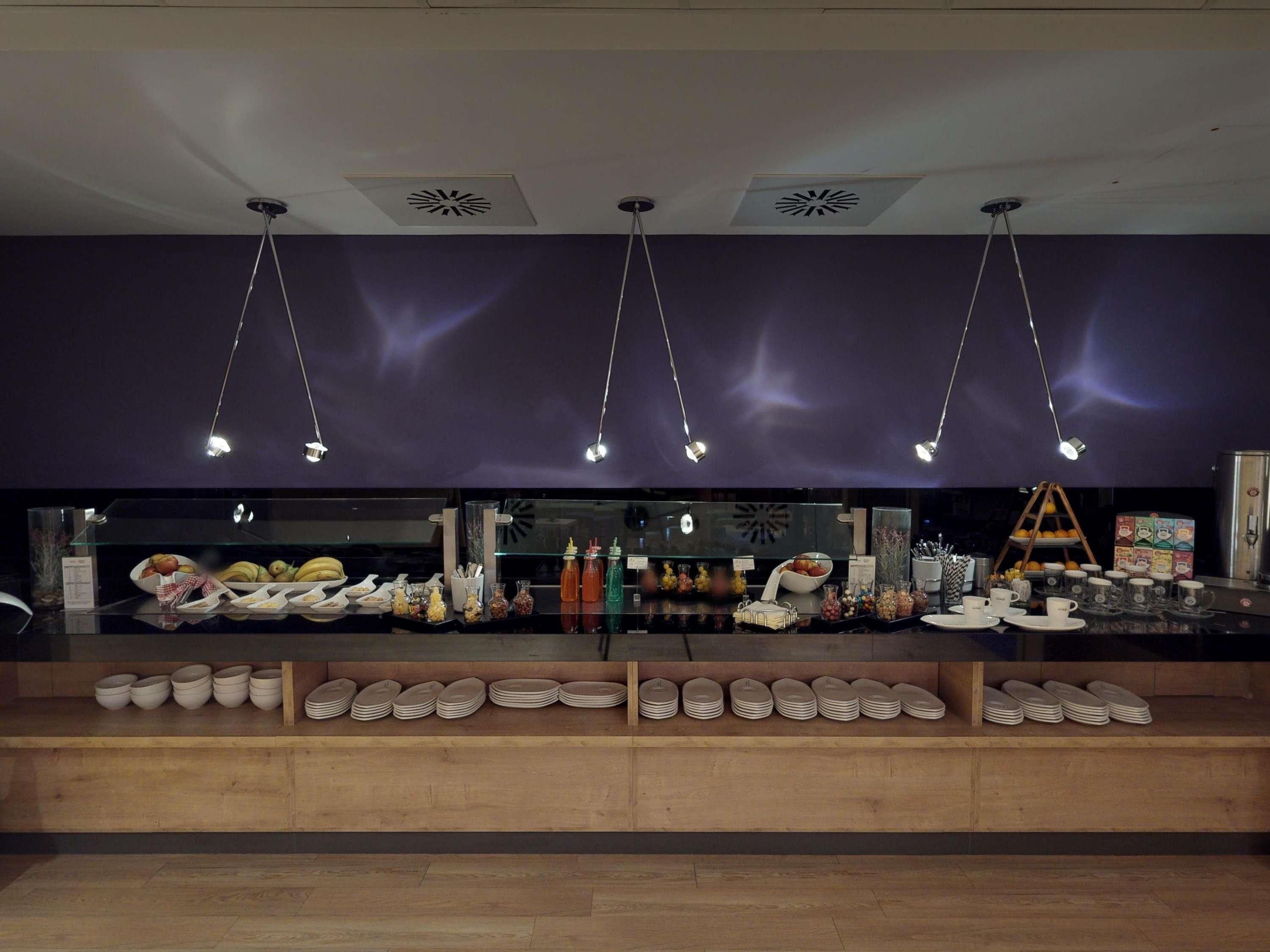Un área de buffet con diferentes opciones de comida y utensilios.
