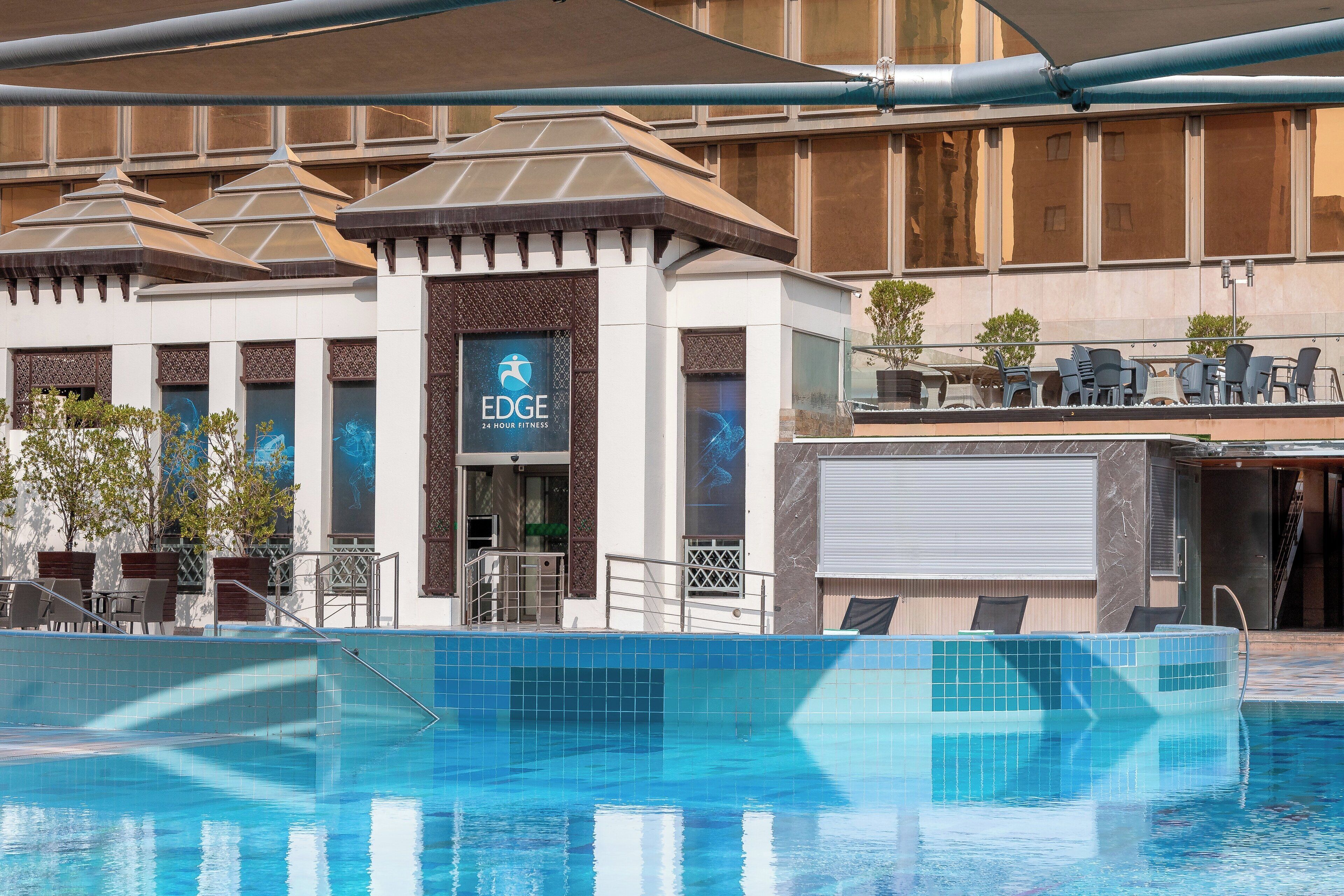 Ein Hotel mit Poolbereich, Außenbereich zum Sitzen und einem Fitnesscenter.