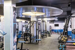 A gym with various exercise machines, weightlifting equipment, and a large mirror. - Holiday Inn Kuwait Al Thuraya City by IHG (Farwaniya)