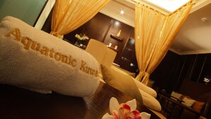 A hotel room with a bed, a chair, and a table with a towel and flower. - Holiday Inn Kuwait Al Thuraya City by IHG (Farwaniya)