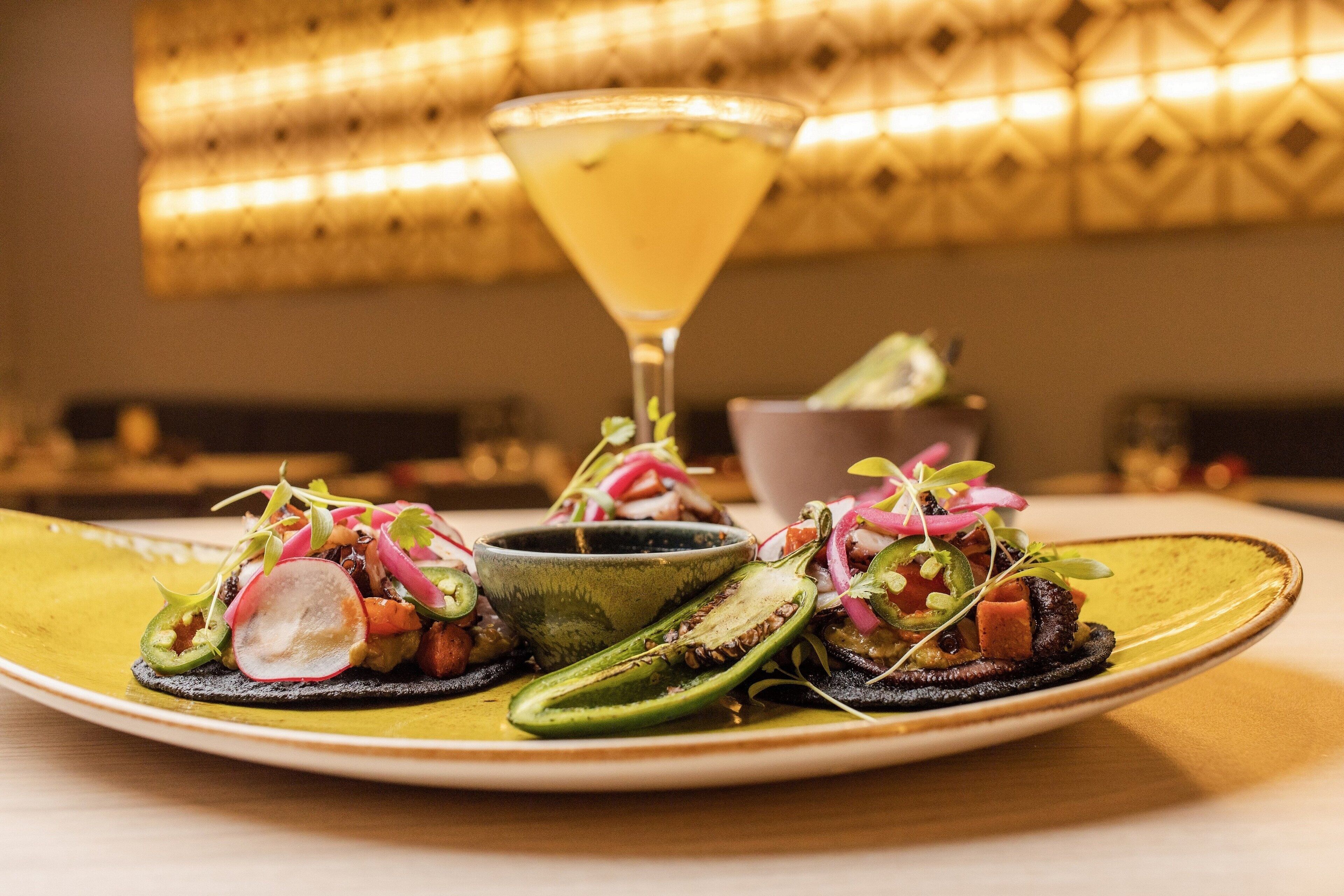 A plate of food with a cocktail on the side.