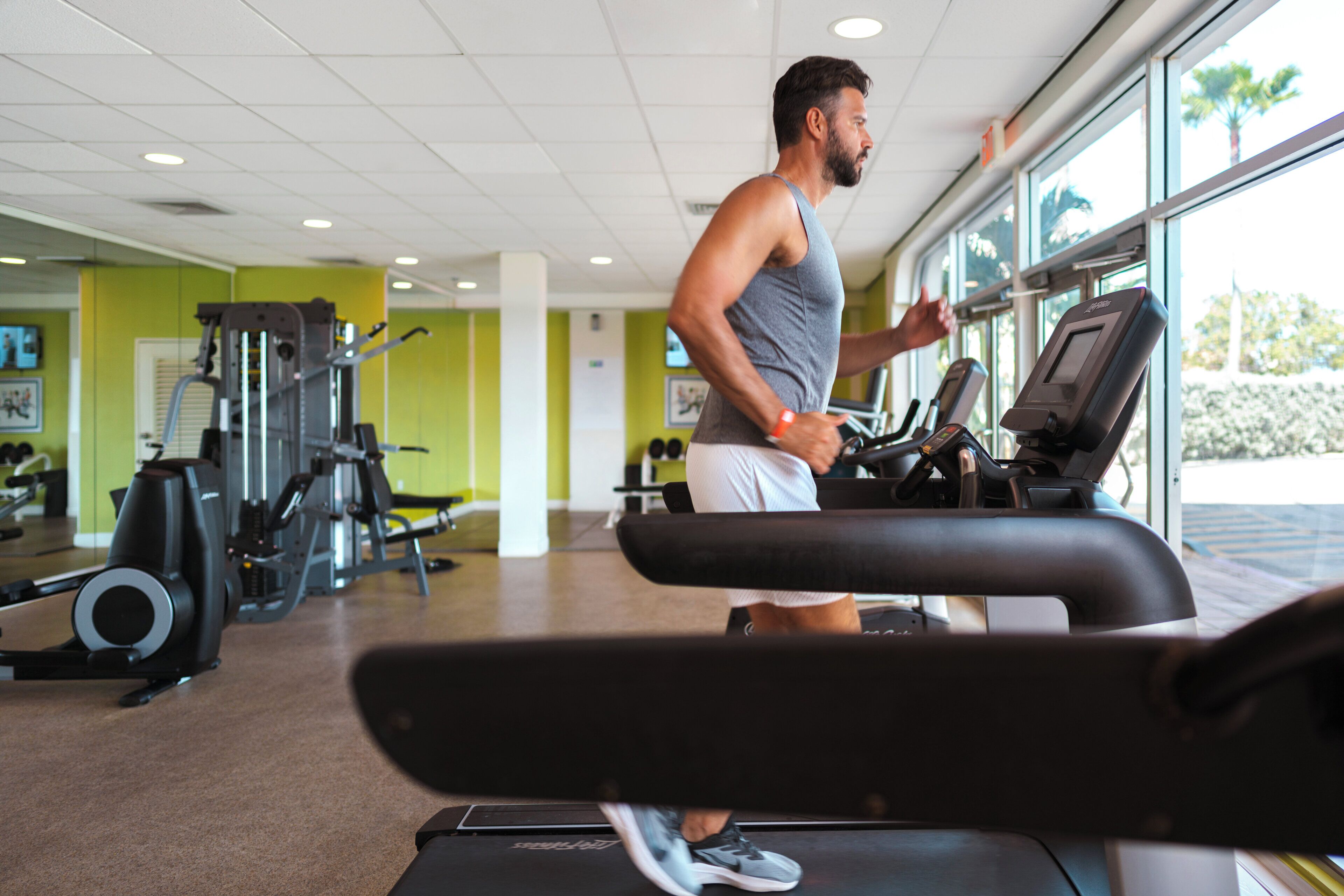 A gym with exercise equipment and a large window.
