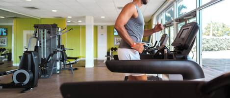A gym with exercise equipment and a large window.