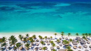 A beach with clear turquoise waters, white sand, and palm trees. - Holiday Inn Resort Aruba - Beach Resort & Casino by IHG (Noord)