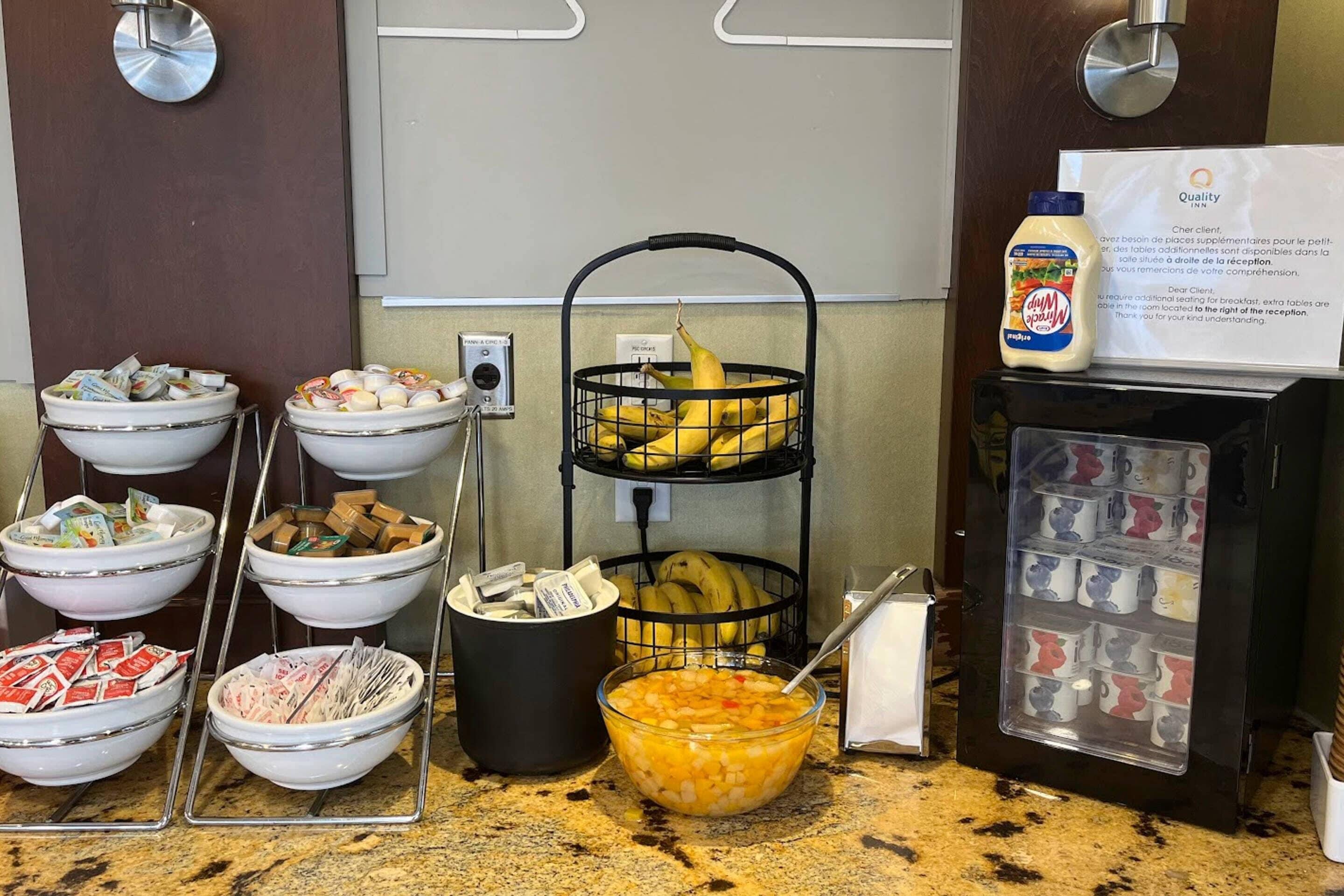 Disposição de buffet com diversos alimentos e um dispensador de bebidas.