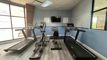 Ein Fitnessraum mit Laufbändern, Crosstrainern und einem stationären Fahrrad.