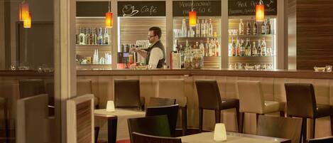 A restaurant with a bar area, tables, and chairs.