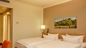 A hotel room with two beds, a painting of a castle, and a chair. - Sunday Hotel Leipzig-Halle (Landsberg)