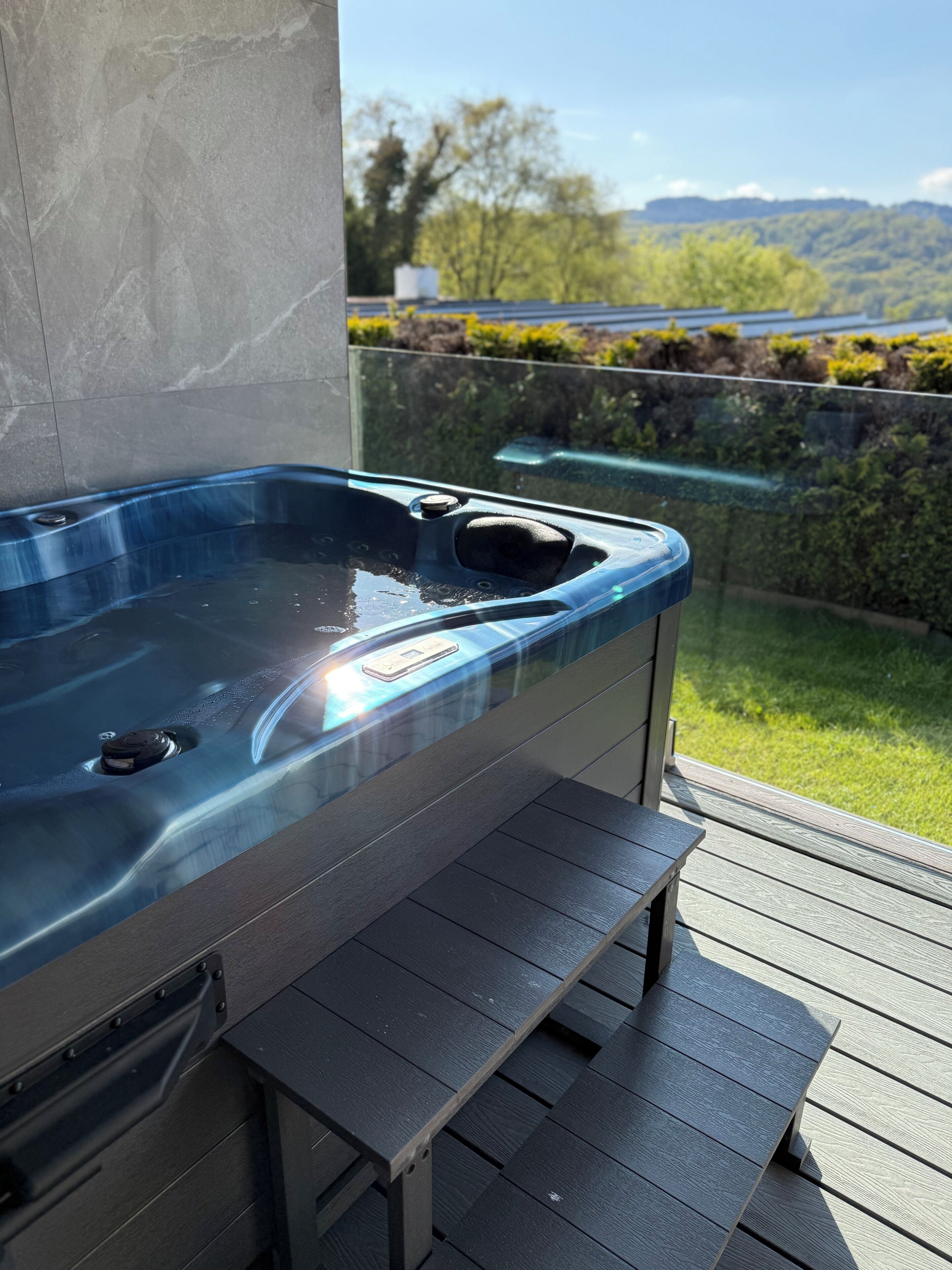 Un bain à remous doté d’une terrasse en bois et offrant une vue dégagée sur le paysage environnant.