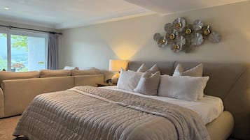 Un dormitorio amplio con una cama grande, un sofá y un adorno en la pared.