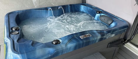 Un jacuzzi con controles, un panel de control y un escalón para entrar.
