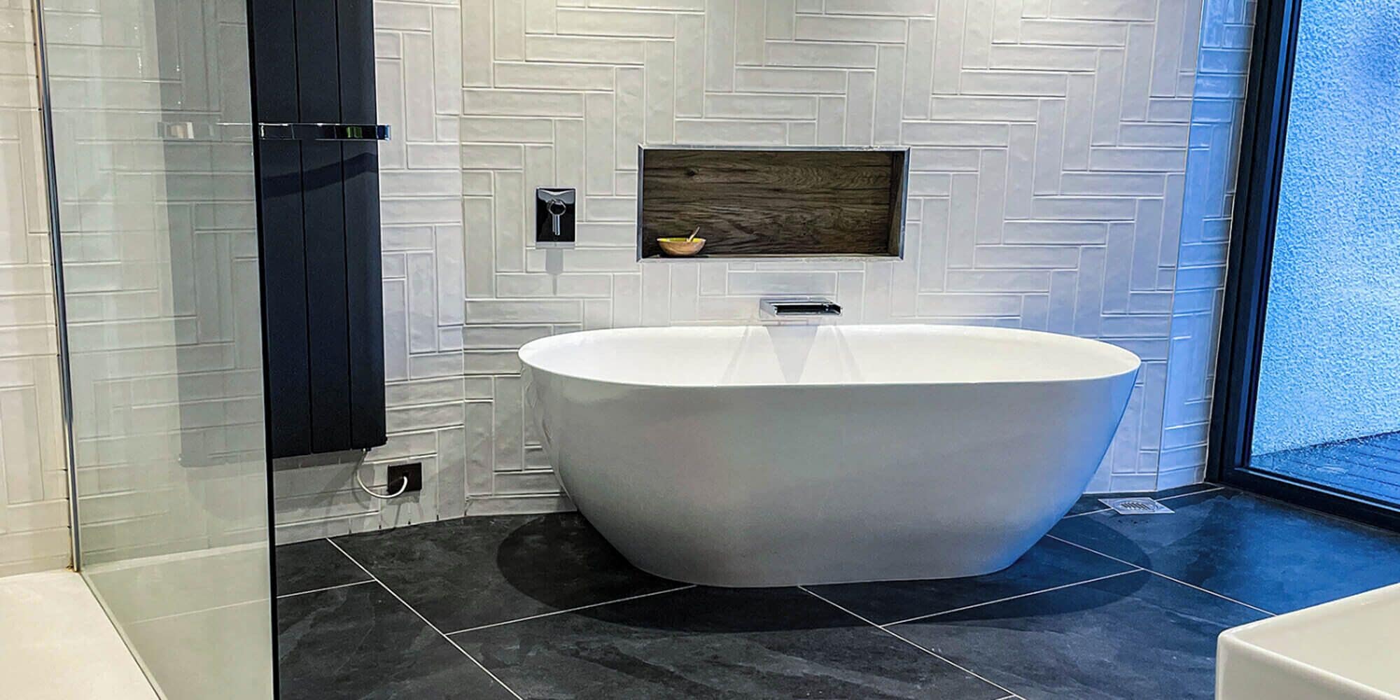 A modern bathroom with a freestanding bathtub, a built-in sink, and a window providing natural light.