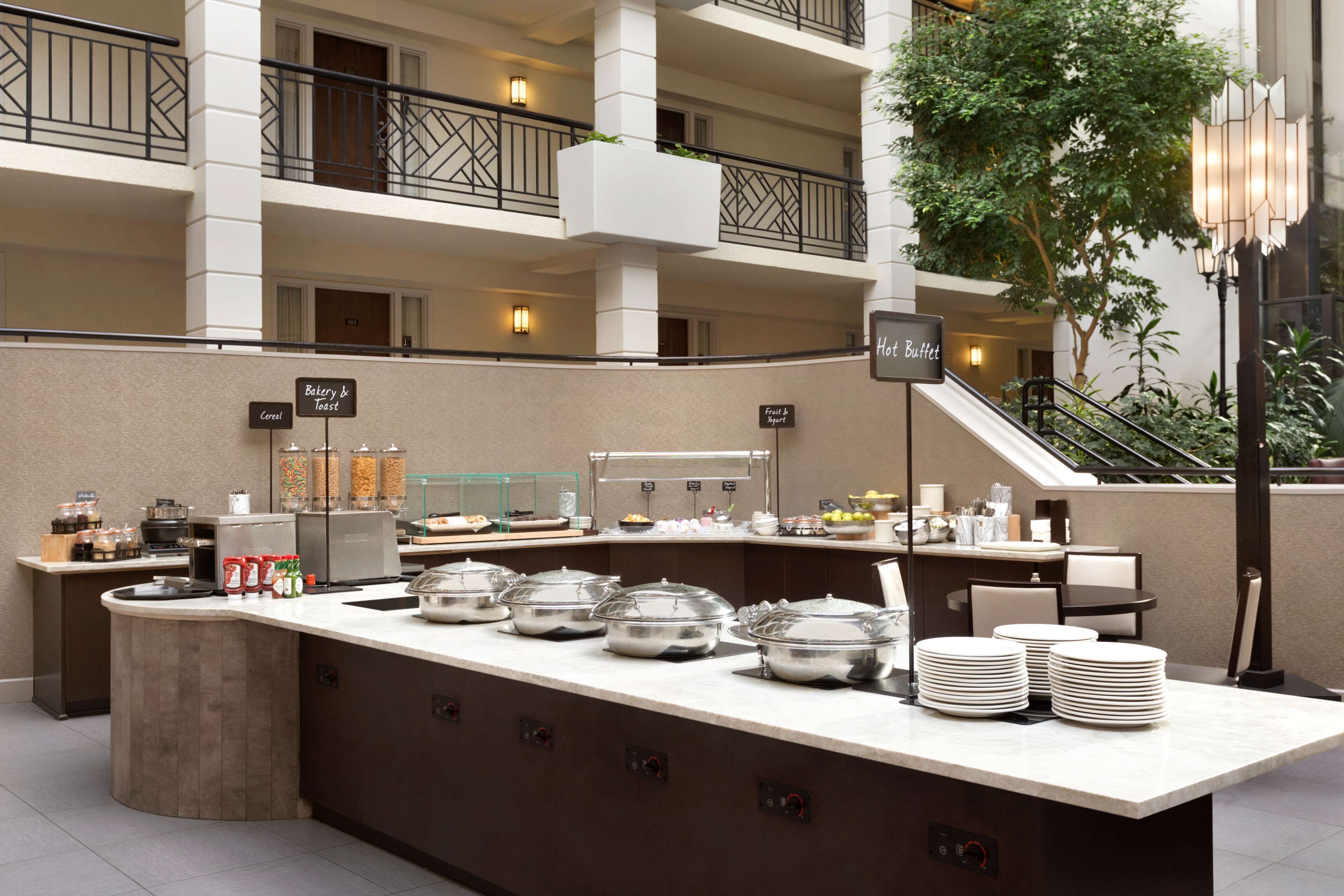 A buffet setup with labeled stations for cereal, fruit, and bread.