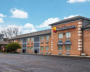 A Comfort Inn hotel with a brick facade, multiple windows, and a parking lot.