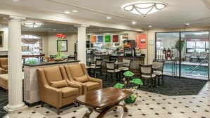 A hotel lobby with a reception desk, seating area, and a pool area. - Comfort Inn Indianapolis South I-65 (Indianapolis)