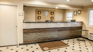 A hotel reception area with a reception desk, a clock, and a sign indicating 'Employees Only'. - Comfort Inn Indianapolis South I-65 (Indianapolis)