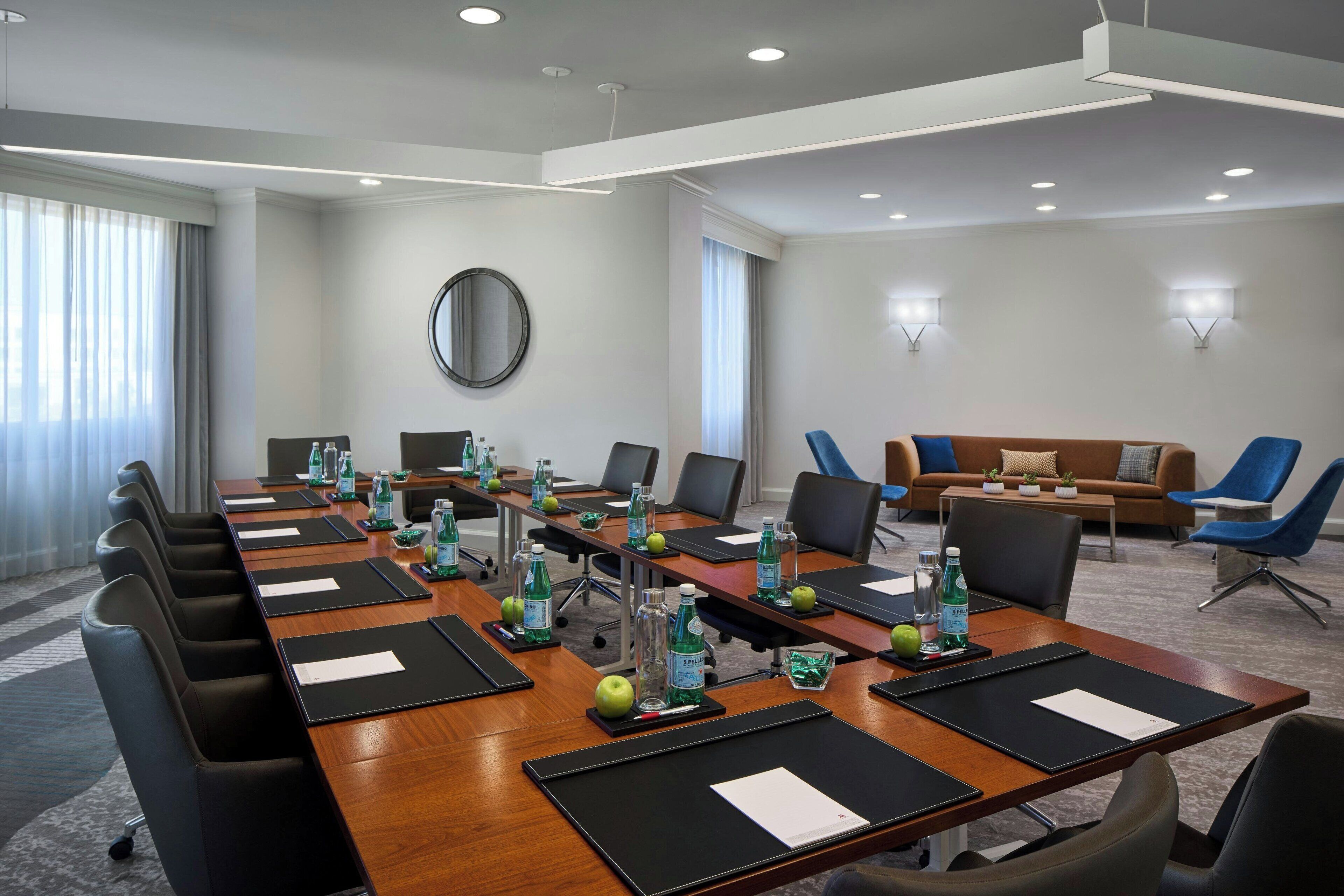 Un salón de conferencias con una larga mesa, sillas y un sofá.