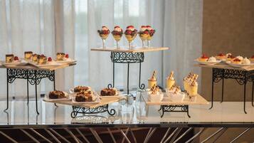 A buffet table with various desserts and beverages.