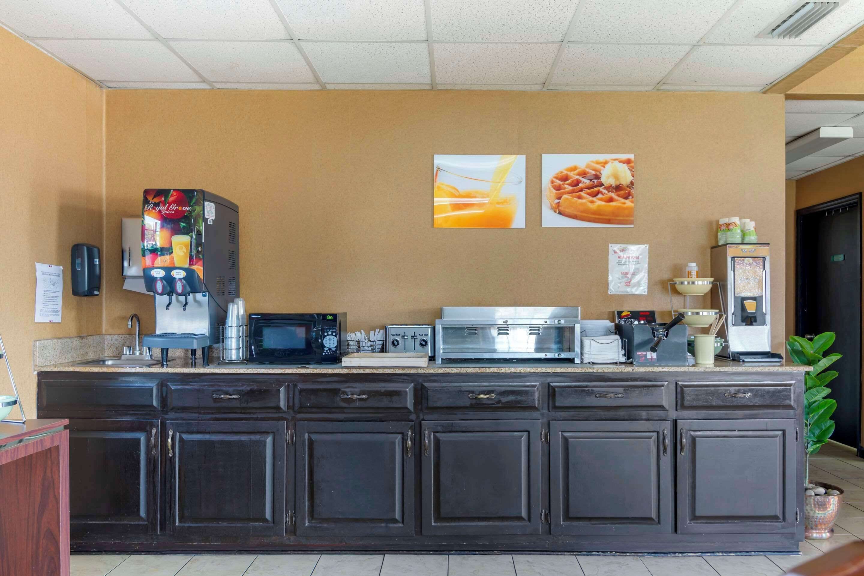 A kitchen area with a coffee machine, microwave, toaster, and refrigerator.