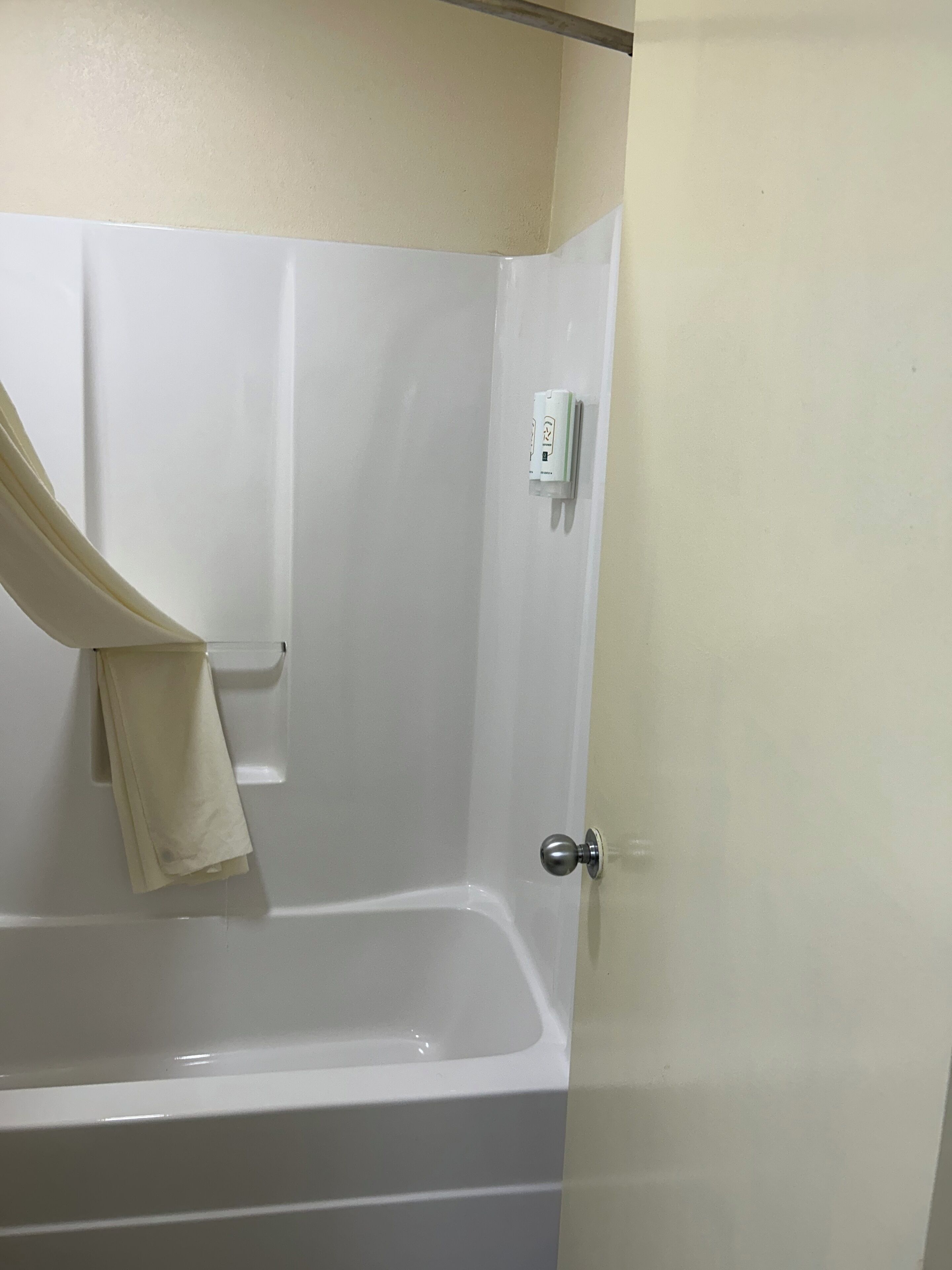 Une salle de bain avec une baignoire, un porte-serviettes et une porte.