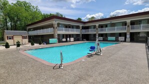 A hotel with a swimming pool, multiple balconies, and a small building with a garage. - Red Roof Inn Bordentown - McGuire AFB (Bordentown)