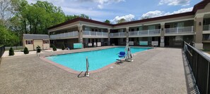 A hotel with a swimming pool, multiple balconies, and a small building with a garage. - Red Roof Inn Bordentown - McGuire AFB (Bordentown)